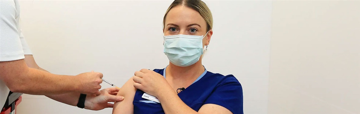 An Austin Health nurse receives her COVID-19 vaccination